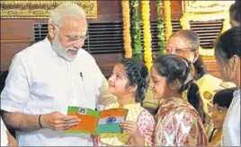  ??  ?? Prime Minister Narendra Modi looks at cards presented by the greatgrand­daughters of former PM Lal Bahadur Shastri on his birth anniversar­y in New Delhi on Monday. ARVIND YADAV/HT PHOTO