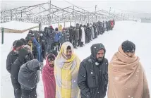  ?? REUTERS ?? Migrants queue for food during snowfall at a makeshift shelter in Bihac, Bosnia and Herzegovin­a on Monday.