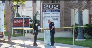  ?? Paul Bersebach / Associated Press ?? Officials on Thursday work outside the scene of a shooting in Orange, Calif. The gunman who killed four people and wounded a fifth at an office complex knew all the victims either through business or personally, Southern California police said.
