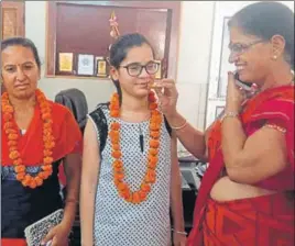  ?? HT PHOTO ?? Heena’s teachers offering her sweets at the Government Senior Secondary School in Hisar.