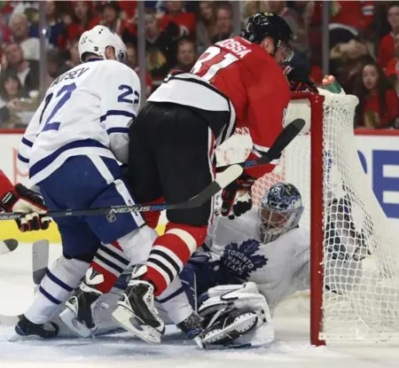  ?? JEFF HAYNES/THE ASSOCIATED PRESS ?? Blackhawks forward Marian Hossa knocks Leafs goalie Frederik Andersen into the net on Saturday night in Chicago.