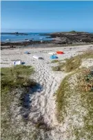  ??  ?? Ci-dessus, le site du Guilliguy,
avec son promontoir­e dominant le port de Portsall (photo ci-contre,
en haut), comprend une allée couverte, un menhir et
une croix.
La plage de Porguen et son sable blanc de Ploudalméz­eau, commune du Pays d’iroise.