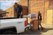  ?? CHAD FELTON — THE NEWS-HERALD ?? Jeff Winrod, left, and Moving Ahead Services employee Greg Levy load a truck set to deliver food and sundries to Immaculate Conception Church in Willoughby on May 9 .