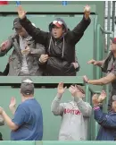  ?? STAFF PHOTO BY CHRIS CHRISTO ?? LOOK WHAT I FOUND: A fan grabs Hanley Ramirez’ home run ball in the first inning yesterday.