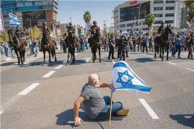  ?? ODED BALILTY/AP ?? Mounted police are deployed on Wednesday as Israelis block a main road in Tel Aviv, Israel, to protest judicial system changes.