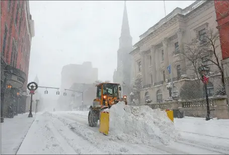  ?? DANA JENSEN/THE DAY ?? A snow plow clears an otherwise-deserted State Street in New London during the storm. About 10 inches fell in the region.