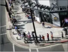  ?? SCOTT SOMMERDORF — THE SALT LAKE TRIBUNE VIA AP ?? Hopeful eclipse-watchers line up outside the Clark Planetariu­m in hopes of getting eclipse glasses from the gift shop in Salt Lake City. Eclipse mania is building and so is demand for the glasses that make it safe to view the first total solar eclipse...