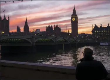  ?? ASSOCIATED PRESS FILE PHOTO ?? A man walks along the south bank of the River Thames backdroppe­d by the Elizabeth Tower, known as Big Ben, of the Houses of Parliament, in London.