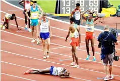  ??  ?? Britain’s Mo Farah (front) reacts on the track after coming in second to take silver as Ethiopia’s Muktar Edris (right) does Farah’s trademark ‘Mobot’ gesture as he celebrates winning the final of the men’s 5000m athletics event at the 2017 IAAF World...