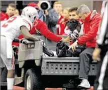  ?? DAVID JABLONSKI / STAFF ?? Ohio State receiver Corey Smith (on cart) is comforted by teammate Dontre Wilson (left) after Smith broke his leg against Indiana on Oct. 3. Smith missed the rest of the season.