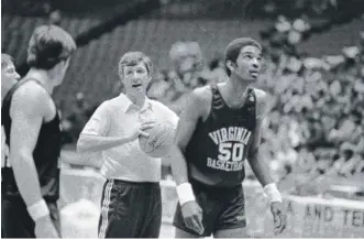  ?? GENE PUSKAR/AP ?? Virginia coach Terry Holland with his team Friday, March 28, 1981, during practice in Philadelph­ia ahead of an NCAA Tournament Final Four game. At right is center Ralph Sampson.