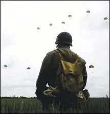  ?? ASSOCIATED PRESS ?? In this file photo taken Wednesday, a WWII enthusiast watches French and British parachutis­ts jumping during a commemorat­ive parachute jump over Sannervill­e, Normandy, France.