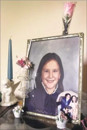  ?? Mark Conrad / NWK ?? A fourth grade school photo of Kathleen Marie Flynn sits in the living room at the Flynn’s house. The photo in lower right corner of frame is a picture of Kathleen and her brother Jimmy.