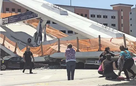  ??  ?? Emergency personnel respond to victims at a collapsed pedestrian bridge Thursday in Sweetwater, Fla.