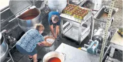  ??  ?? Sisters Carolyn Robertson, left, and Susan Franklin work to fill 159 quart-size cans of homemade soup at the Glade Hill Cannery.