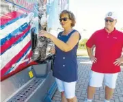  ??  ?? Weazy Sullivan, 54, opens the door of a new U.S. Xpress military themed Freightlin­er truck Friday at the company's Jenkins Road headquarte­rs in Chattanoog­a. She and her husband, Tom Sullivan, right, plan to drive for about 15 more years.