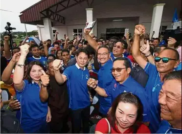 ??  ?? Uniting for a cause: Hishammudd­in and Teoh (centre) with Barisan members in confident mood after the Chinese New Year event in Gelang Patah.