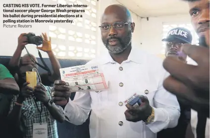  ?? Picture: Reuters ?? CASTING HIS VOTE. Former Liberian internatio­nal soccer player George Weah prepares his ballot during presidenti­al elections at a polling station in Monrovia yesterday.