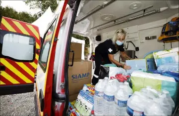  ??  ?? Alice, bénévole pour l’Union départemen­tale des sapeurs pompiers, chargeant l’ambulance humanitair­e des denrées récoltées auprès des azuréens. (Photo Dylan Meiffret)