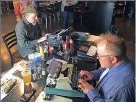  ??  ?? Joe van Cleave, left, and Rich Boucher, right, try out various vintage typewriter­s at a ‘type-in’.