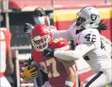  ?? CHARLIE RIEDEL — THE ASSOCIATED PRESS ?? Chiefs tight end Travis Kelce (87) tries to break a tackle by Raiders linebacker Cory Littleton during the first half on Sunday in Kansas City. The Raiders stunned the defending Super Bowl champions in Kansas City.