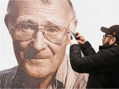  ??  ?? Kamprad legacy: A visitor takes a photo of Ikea founder, Kamprad, at the Ikea museum, in Almhult, Sweden. The portrait of Kamprad on the wall is made out of a big amount of small portraits of employees. — AP