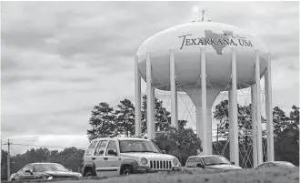  ??  ?? A water tower proclaims Texarkana is “Twice as Nice” just off of Interstate 30. On the Arkansas side, poor residents have better insurance options than those across the state line in Texas.
