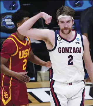  ?? Associated Press ?? TOUGH OPPONENT — Gonzaga forward Drew Timme, right, celebrates in front of USC guard Tahj Eaddy, left, after making a basket during the first half of an Elite 8 game in the NCAA men’s basketball tournament at Lucas Oil Stadium, Tuesday in Indianapol­is.