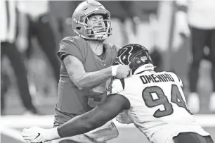  ?? RAJ MEHTA/USA TODAY SPORTS ?? Lions quarterbac­k Matthew Stafford gets hit by Texans defensive end Charles Omenihu after making a pass during the second quarter at Ford Field on Nov. 26.