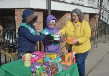  ?? LAUREN HALLIGAN - MEDIANEWS GROUP ?? Assemblywo­man Carrie Woerner purchases Thin Mints and Do-si-Dos at Girl Scout Troop #3031’s cookie booth on Saturday morning on Broadway in Saratoga Springs.