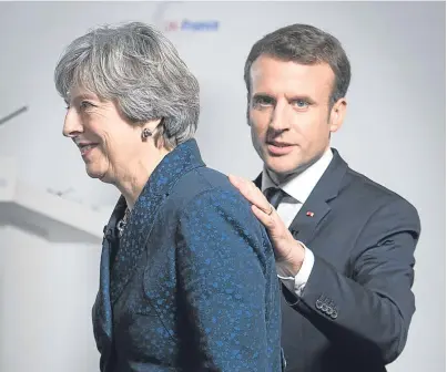  ?? Picture: Getty. ?? A helping hand: French President Emmanuel Macron and Prime Minister Theresa May at the Royal Military Academy Sandhurst yesterday.