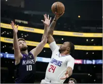  ?? RYAN SUN — THE ASSOCIATED PRESS ?? The Clippers' Norman Powell, who scored 21 points, shoots against Domantas Sabonis of the Kings on Sunday night.