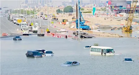 ?? GIUSEPPE CACACE/AGENCE FRANCE-PRESSE ?? CARS are stranded on a flooded street in Dubai following heavy rains. The city’s giant highways were clogged by flooding and its major airport was in chaos as the Middle East financial center remained gridlocked after the heaviest rains on record.