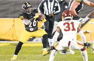  ?? KEITH SRAKOCIC/AP ?? Steelers running back Anthony McFarland carries the ball with Washington strong safety Kamren Curl defending during the second half Monday in Pittsburgh.