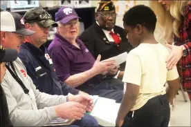  ?? (Matt Hutcheson/News-Times) ?? A group of U.S. Armed Forces veterans visited and spoke to Yocum Primary School first-graders Friday morning. The program ended with the students giving thank-you cards to the veterans.