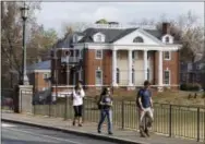  ?? THE ASSOCIATED PRESS ?? In this Monday, Nov. 24, 2014, file photo, University of Virginia students walk to campus past the Phi Kappa Psi fraternity house at the University of Virginia in Charlottes­ville, Va. Rolling Stone is casting doubt on the account it published of a...