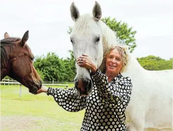  ?? Picture: SUE MACLENNAN ?? STAR ATTRACTION: Eagles Liquorice with owner Robyn Gerber in his paddock in Bathurst. Looking on (and hoping for a treat) is Cadillac. The 17.1-hands SA Warmblood ridden by Gerber is among the top-class horse-and rider combinatio­ns expected to be in action at the Bathurst Agricultur­al Show, from March 22-24.