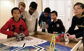  ?? CONTRIBUTE­D ?? Aditya Bora (third from left) coached a robotics team from Dolvin Elementary in the basement of his Johns Creek house as part of the Chief Science Officer program.