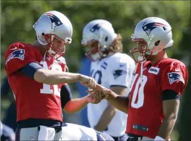  ?? STEVEN SENNE - THE ASSOCIATED PRESS ?? New England Patriots quarterbac­k Tom Brady, left, grasps the hand of fellow quarterbac­k Jimmy Garoppolo during training camp Tuesday.