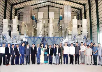  ??  ?? People pose for in front of an Amru Rice (Cambodia) Co Ltd rice storage facility in Kampong Thom during its inaugurati­on in July.