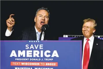  ?? MORRY GASH AP ?? Wisconsin Republican gubernator­ial candidate Tim Michels speaks as former President Donald Trump listens at a rally Friday. Michels won Tuesday’s primary and will face Gov. Tony Evers in November.