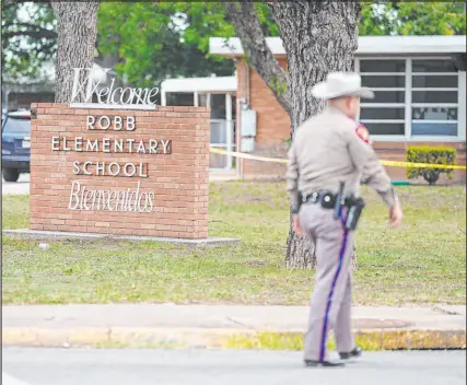  ?? Allison Dinner Tribune News Service ?? An officer walks outside of Robb Elementary School in Uvalde, Texas, on May 24, 2022. An 18-yearold gunman killed 19 children and two teachers at the elementary school.