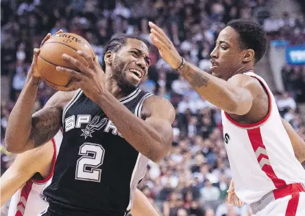  ?? NATHAN DENETTE / THE CANADIAN PRESS FILES ?? San Antonio Spurs’ forward Kawhi Leonard is shown being defended by Toronto Raptors’ guard Demar Derozan.