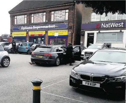  ??  ?? UNDER SIEGE: Armed officers dressed in black can be seen outside the NatWest branch in Birmingham