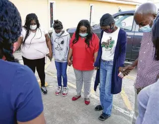  ?? Melissa Phillip / Staff photograph­er ?? Sherkeitha Kennedy, second from right, is surrounded by family and friends in a prayer circle before a news conference Tuesday at St. Paul Baptist Church in Brookshire.