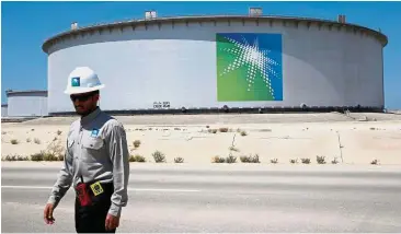  ??  ?? Major deals: An Aramco employee on duty near an oil tank at the company’s Ras Tanura oil refinery and terminal. Earlier this week, Aramco says it has signed 15 agreements worth US$34bil if they are all seen through. — Reuters