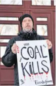  ?? FOTO: CHRISTIAN THIELE/DPA ?? Der russische Umweltakti­vist Wladimir Sliwjak demonstrie­rt mit einem Schild, auf dem „Coal Kills“(„Kohle tötet“) steht.