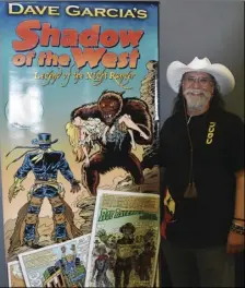  ?? PHOTO TOM BODUS ?? Local artist Dave Garcia stands with a poster promoting his newest comic book series at the Imperial Valley Comic-Con Saturday.