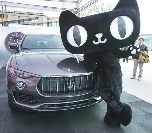  ?? XU KANGPING / FOR CHINA DAILY ?? A Tmall mascot poses with a Maserati SUV Levante 350HP in Hangzhou, Zhejiang province, after the luxury carmaker sold its first 100 models on the Alibaba online platform. Starting at 999,800 yuan, Maserati sold all 100 cars in 15 minutes last year.