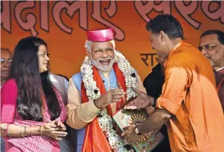  ?? - PTI ?? GARNERING SUPPORT: BJP MP Kirti Azad presenting a memento to Prime Minister Narendra Modi during an election rally in Darbhanga on Monday.